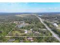 Aerial view shows the boundaries of a property with a pond and rural structures amongst dense trees and foliage at 964 1St Dirt Rd, Venice, FL 34292