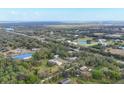 A high-definition aerial view displays a series of rural residences, foliage, and pond in the background at 964 1St Dirt Rd, Venice, FL 34292
