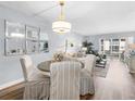 Cozy dining area with chandelier, decor mirrors, and hardwood floors, offering an inviting space for meals and gatherings at 995 Laguna Drive # 303, Venice, FL 34285