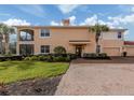Inviting two-story home features a lush lawn, brick walkway, and attached garages at 142 Bella Vista Ter # A, North Venice, FL 34275