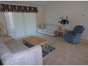 Cozy living room area with neutral carpeting, comfortable seating, and natural light at 157 Algiers Dr, Venice, FL 34293