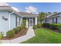 A welcoming front entrance featuring a screened porch and meticulously maintained landscaping at 1610 Monarch Dr # 1610, Venice, FL 34293