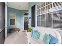 Inviting front porch featuring a cozy white wicker bench with blue pillows, offering a relaxing outdoor space at 1610 Monarch Dr # 1610, Venice, FL 34293