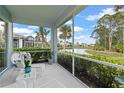 Covered lanai overlooking a serene lake and lush landscaping at 1610 Monarch Dr # 1610, Venice, FL 34293