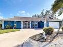 Charming single-Gathering home features a two-car garage, circular drive, and beautiful landscaping at 2 Windsor Dr, Englewood, FL 34223