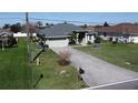Aerial view of charming home with well-maintained lawn, two-car garage, and front yard at 2115 Pan American Blvd, North Port, FL 34287