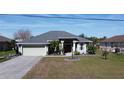 Charming one-story home featuring a two-car garage and manicured landscaping on a sunny day at 2115 Pan American Blvd, North Port, FL 34287