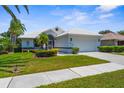Beautiful home featuring manicured lawn, trimmed shrubs, tile roof and two-car garage with lovely curb appeal on a sunny day at 213 Venice Palms Blvd, Venice, FL 34292