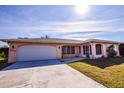 Inviting home featuring a spacious driveway, a two-car garage, and a cozy, screened-in porch at 2221 Bal Harbour Dr, Venice, FL 34293
