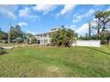 Beautiful two-story house with a metal roof and wrap-around balcony surrounded by lush greenery at 2371 Scenic Dr, Venice, FL 34293