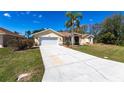 A charming single-story home showcasing a long driveway leading to an attached two-car garage at 255 San Cristobal Ave, Punta Gorda, FL 33983