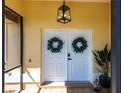 Inviting entryway featuring double doors adorned with wreaths and modern lighting at 255 San Cristobal Ave, Punta Gorda, FL 33983