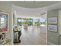 Open-concept living space with wood floors, balcony access, dining area, and a modern kitchen at 385 N Point Rd # 404, Osprey, FL 34229