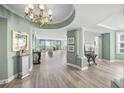 Bright and airy living room with wood floors, a decorative chandelier, and stunning views of the water at 385 N Point Rd # 404, Osprey, FL 34229