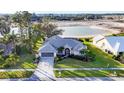 Well-maintained home features lush landscaping and a serene water view at 5051 Greenway Dr, North Port, FL 34287