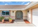 Welcoming front entrance with arched double doors, classic sconces, and lush potted plants at 5061 Richmond Ter, North Port, FL 34287