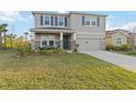 Two-story home features a neutral exterior, blue shutters, a two-car garage, and a charming front porch at 5767 Woodland Sage Dr, Sarasota, FL 34238