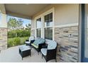 Inviting front porch with stylish seating, stone accents, and ample natural light at 5767 Woodland Sage Dr, Sarasota, FL 34238