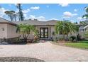 Attractive single-story home with paver driveway, double door entry, and mature palms at 612 Poinsettia Dr, Venice, FL 34285