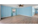 Inviting bedroom featuring blue walls, light wood floors, and a modern ceiling fan at 891 Grado Dr, Venice, FL 34285