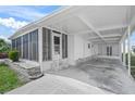 Angle view of the exterior featuring a carport, screened porch, and landscaped exterior at 891 Grado Dr, Venice, FL 34285