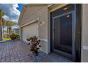 Inviting front porch and a close-up of the front door, with nice stonework and landscaping details at 8969 Mondial Ct, Venice, FL 34293