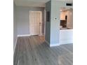 Bright living room with light gray walls and sleek wood-look gray tile throughout at 902 Gibbs Rd # 181, Venice, FL 34285