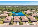 Wonderful aerial view of the villa community surrounding a lake with mature trees and fountain at 1018 Yosemite Dr, Englewood, FL 34223