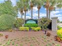 Elegant Oak Forest community sign surrounded by lush landscaping, flowers, and mature palm trees at 1018 Yosemite Dr, Englewood, FL 34223