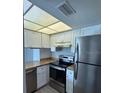 Stainless steel appliances with white cabinets and marble countertops in a compact kitchen at 1190 Longfellow Way # 135C, Sarasota, FL 34243
