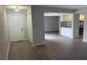 Open floor plan with gray walls, wood-look flooring, a front door and a view of the kitchen at 1190 Longfellow Way # 135C, Sarasota, FL 34243