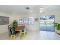 Bright dining area with white tile floors and glass sliders leading to the pool area at 1200 Yawl Way, Venice, FL 34285