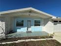 Inviting front porch with blue trim, tiled flooring, and a 'welcome' mat offers a warm entrance to the home at 12613 4Th Isle, Hudson, FL 34667