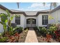 Paver walkway leading to the front entrance, enhanced by lush landscaping and architectural details at 13867 Vadini St, Venice, FL 34293
