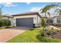 Well-manicured lawn and landscaping complement this single-story home with brick driveway and a tile roof at 13867 Vadini St, Venice, FL 34293