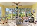 Bright sunroom with tiled floor and large windows offering beautiful backyard views at 161 Valencia Lakes Dr, Venice, FL 34292