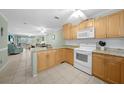 Open kitchen featuring tile floors, wood cabinets, granite countertops, and modern appliances at 1636 Stickney Point Rd # 36-201, Sarasota, FL 34231