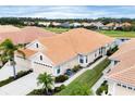 Exterior view of a well-maintained home with tile roof, lush lawn, and landscaping at 1697 San Silvestro Dr, Venice, FL 34285