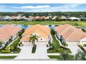 Charming home exterior featuring a tile roof, well-manicured lawn, palm trees, and a spacious driveway at 1697 San Silvestro Dr, Venice, FL 34285