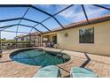 Relaxing backyard oasis with a screened-in pool, brick paved patio and comfortable lounge chairs at 19340 Bluff Dr, Venice, FL 34292