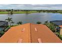 Rooftop view of a clay tile roof overlooking lake and golf course at 23415 Waverly Cir, Venice, FL 34293