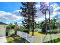 Spacious backyard enclosed with a white vinyl fence and lush trees, perfect for outdoor enjoyment and privacy at 23495 Altman Ave, Punta Gorda, FL 33980