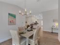 Dining room with seating for six, a modern chandelier, and views of the open concept kitchen at 2572 Averland Loop, North Port, FL 34287