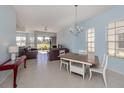 Open-concept living room features a dining area, tan tile floor, and sliding glass doors to the outdoors at 2602 Ravinia Cir # 2602, Venice, FL 34292