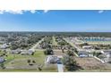 Expansive aerial view of a residential neighborhood with lush greenery and a tranquil pond in the distance at 2783 Biscayne Dr, North Port, FL 34287