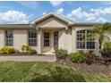 Charming front entrance with decorative door, pathway, well-manicured lawn and mature landscaping at 29692 Niagara Ct, Englewood, FL 34223