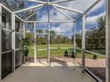 Inviting screened porch offering peaceful views of the green backyard and blue skies at 29692 Niagara Ct, Englewood, FL 34223