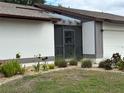 Close-up of the cozy, screened front porch with decorative landscaping at 404 Elder St # 230, Englewood, FL 34223