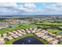 Expansive aerial view of a golf course community, with a lake, lush greenery, and homes at 4301 Whispering Oaks Dr, North Port, FL 34287
