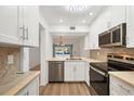 Bright kitchen features white cabinetry, stainless steel appliances, and tile backsplash at 454 Cerromar Rd # 174, Venice, FL 34293